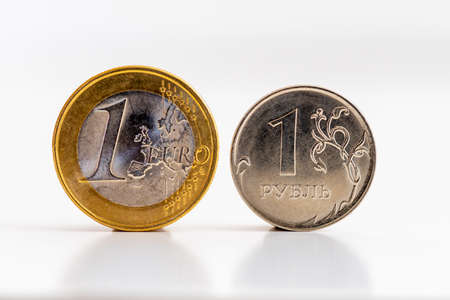 Coins of 1 euro and 1 ruble on a white background. Concepts of exchange rates, financial...