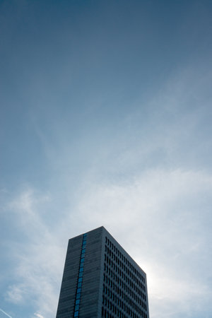 low angle view of modern skyscraper with blue sky and white clouds
