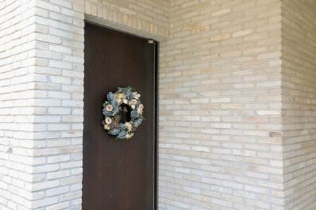 Wooden door with wreath on the wall, closeup of photoの写真素材