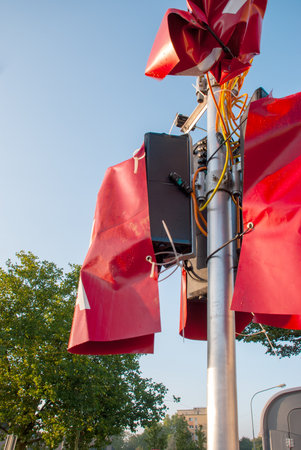 Red ribbons on a pole with electronics and cables in an urban settingの写真素材
