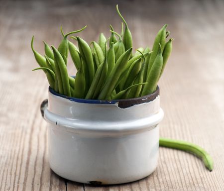 Freshly Picked Green Beans In An Old Enamel Mug On A Wooden Surface