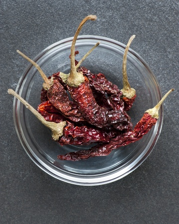 A Dish Of Whole Dried Kashmiri Chillis, Against A Slate Work Surfaceの写真素材