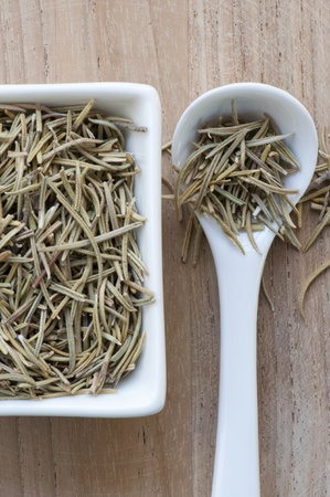 Dried Rosemary In Dish With Spoon, Laid Up On A Wooden Surfaceの写真素材