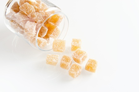Cubes of Crystallized Ginger Spilling Out of a Glass Storage Jarの写真素材
