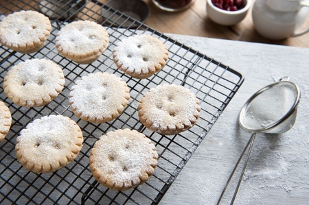 Freshly Baked Mince Pies on a Cooling Rack and Been Sprinkled With Icing Sugarの写真素材