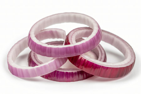 Red onion rings stacked together on a white background showcase their vibrant purple color and interesting texture perfect for illustrating healthy eating or adding visual interest to culinary projecの写真素材