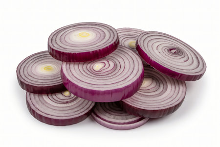 Sliced red onions are stacked artistically on a clean white surface showcasing their vibrant purple color and intricate ring patterns perfect for culinary use in salads or cooking.の写真素材