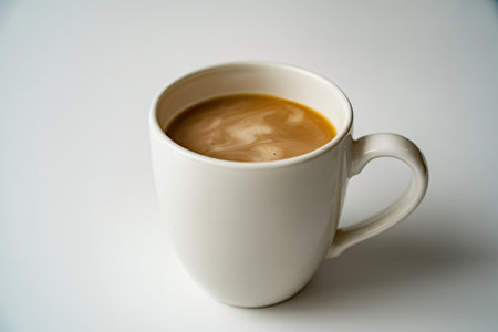 Coffee fills a white mug on a white background creating a clean and simple image representing a morning beverage a warm drink and a moment of peaceful relaxation.の写真素材