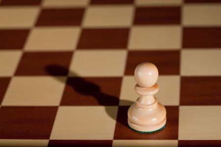 Chess piece - a white pawn on a chessboard.の写真素材