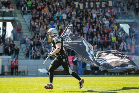 INNSBRUCK, AUSTRIA - MARCH 29, 2014: LB Christoph Schilcher (#55 Raiders) leads his team on the field before an AFL football game.のeditorial素材