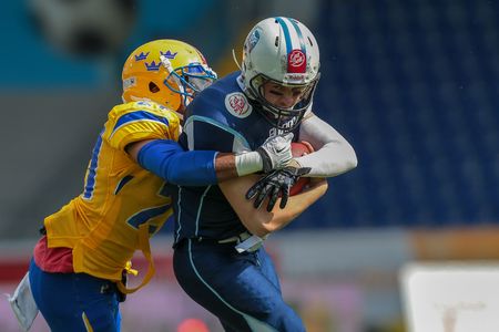 ST. POELTEN, AUSTRIA - JUNE 1, 2014: QB Miro Kadmiry (#7 Finland) is tackled by DB Philip Minja (#21 Sweden).のeditorial素材
