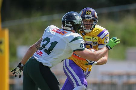 VIENNA, AUSTRIA - JUNE 22, 2014: WR Stefan Postel (#88 Vikings) is tackled by CB Christian Kober (#31 Dragons).のeditorial素材
