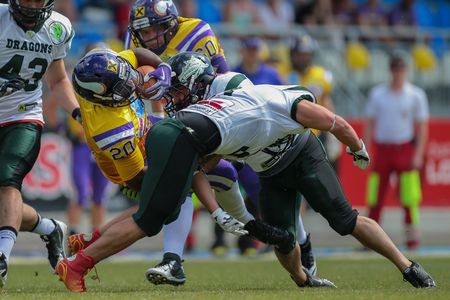 VIENNA, AUSTRIA - JUNE 22, 2014: RB Islaam Amadu (#20 Vikings) is tackled by S Sascha Verhoeven (#3 Dragons).のeditorial素材