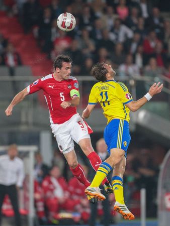 VIENNA, AUSTRIA - SEPTEMBER 9, 2014: Christian Fuchs (#5 Austria) and Johan Elmander (#11 Sweden) fight for the ball in an European Championship qualifying game.のeditorial素材