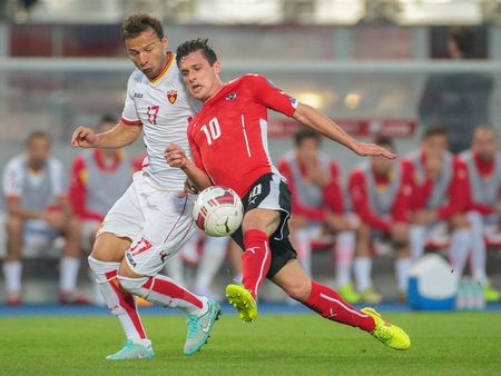 VIENNA, AUSTRIA - OCTOBER 12, 2014: Elsad Zvertovic (#17 Montenegro) and Zlatko Junuzovic (#10 Austria) fight for the ball in an European Championship qualifying game.のeditorial素材