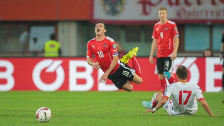 VIENNA, AUSTRIA - OCTOBER 12, 2014: Elsad Zvertovic (#17 Montenegro) fouls Zlatko Junuzovic (#10 Austria) in an European Championship qualifying game.のeditorial素材