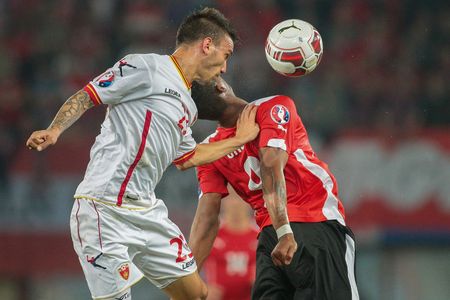 VIENNA, AUSTRIA - OCTOBER 12, 2014: Rubin Okotie (#9 Austria) and Marko Simic (#23 Montenegro) fight for the ball in an European Championship qualifying game.のeditorial素材