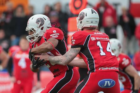 VIENNA, AUSTRIA - April 4, 2016: Grant Enders (New Yorker Lions Braunschweig) hands the ball to Chris Smith (New Yorker Lions Braunschweig). in a game of the Big Six Football League.のeditorial素材