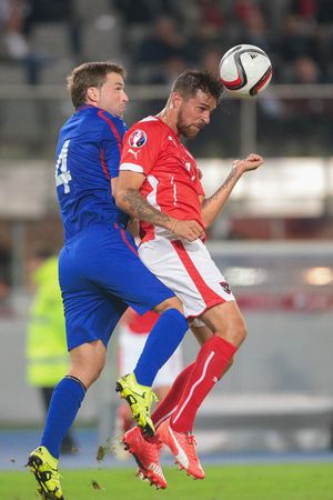 VIENNA, AUSTRIA - SEPTEMBER 5, 2015: Iulian Erhan (Moldavia) and Martin Harnik (Austria) fight for the ball in an European Championship qualification game.のeditorial素材