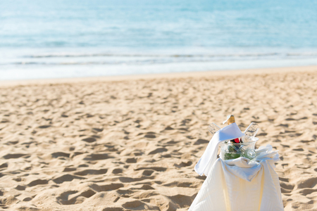 Chilled champagne and wine glasses in bucket setup on the beach.の写真素材
