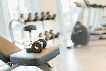 Two dumbbells on the exercise bench. Gym equipment.