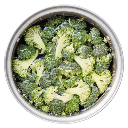 Green broccoli sliced in water in the pot. Isolated on white.の写真素材
