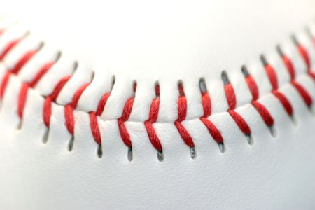 Close up of a white baseball with red seamsの写真素材