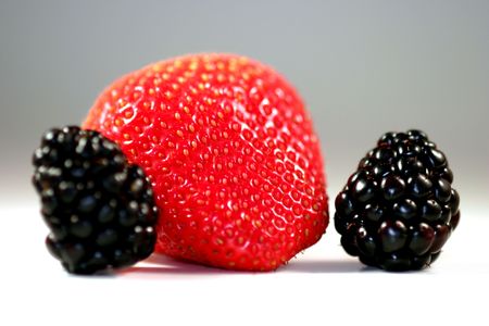 Red strawberry with blackberries on white or light background.の写真素材
