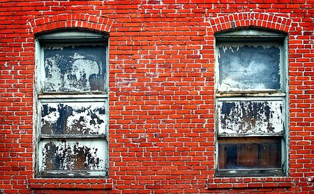 Two old windows in a rustic red brick wall.の写真素材