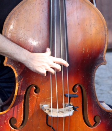 Hands playing a brown wooden bassの写真素材