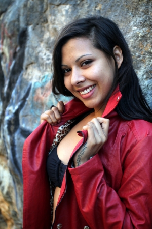 Young Hispanic woman dark hair with a read jacket の写真素材