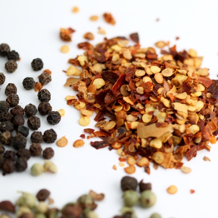 Closeup of chili flakes, black and green pepper の写真素材