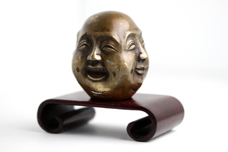 Chinese four faced figure on a little stand with white background の写真素材