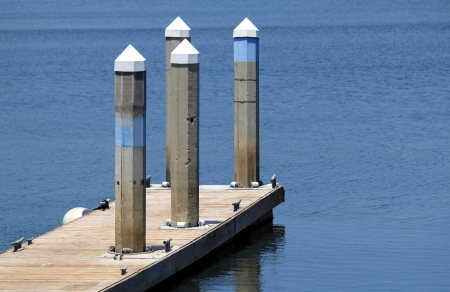 A dock in a harbor for sailboats with poles.の写真素材