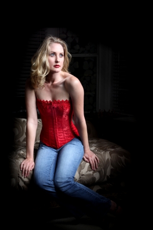 Sexy blond woman sitting in the dark の写真素材