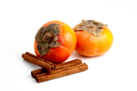 Closeup of persimmons and cinnamon on white background.の写真素材