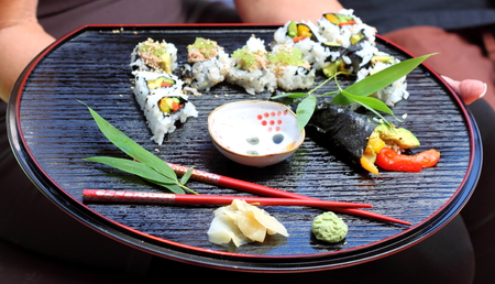 Nicely decorated presentation of sushi on a black serving plate.の写真素材