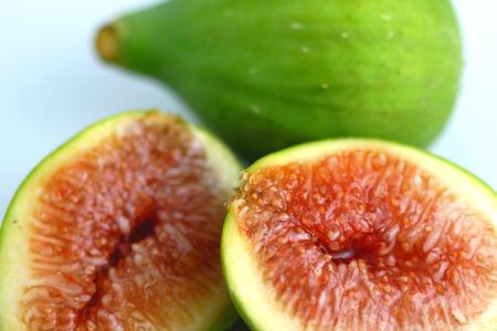 Green fig cut open on white background.の写真素材