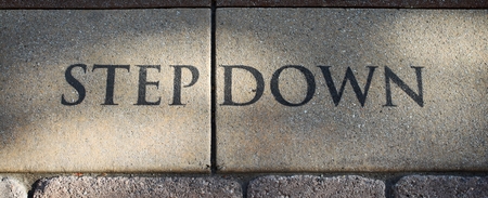 Stone step Down sign on the ground.の写真素材