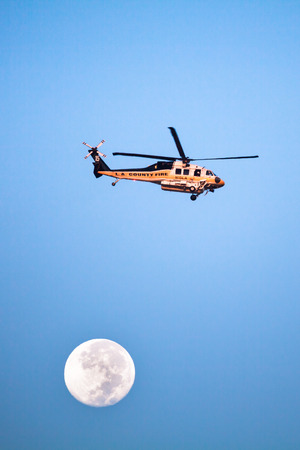 SAN DIMAS, CA - SEPT 10, 2014: A Los Angeles County Fire helicopter makes a pass before proceeding to make a water drop on a wildfire in the San Gabriel Mountains.のeditorial素材