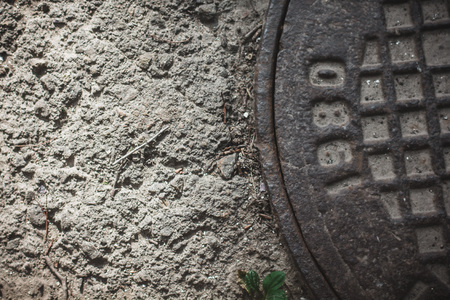 Iron hatch with asphalt backgroundの写真素材