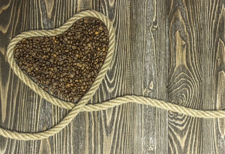 Heart shape made from coffee beans. Background for greeting cards for the holiday Valentine's Day.の写真素材