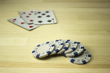 Poker chips and playing cards on the table. Focus on chips
