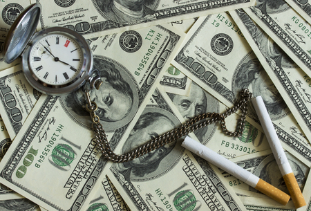 Background texture of banknotes in denominations of one hundred dollars scattered on a table and an...