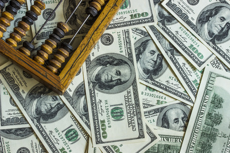 Background texture of banknotes in denominations of one hundred dollars scattered on a table and an...