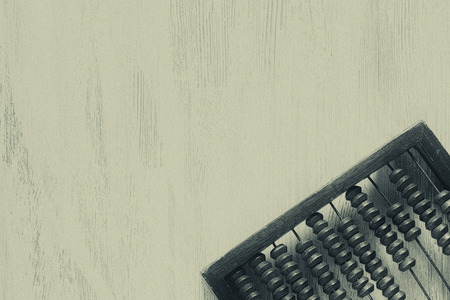 Old wooden scratched vintage decimal abacus on a blue wooden board for the background. Top view....