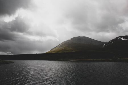 Lake in front of cloudy mountains