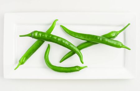 Green fresh pepper on white rectangular plateの写真素材