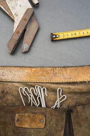 Slaters hand scissors measuring tape and old belt bag for processing slateの写真素材