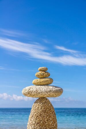 Esotericism meditation balance pebble in front of a blue sky